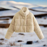 Women's beige high collar warm fleece winter jacket with long sleeves, made from woolen textile, displayed against a wooden background.