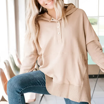 
A woman wearing a casual beige hoodie with buttoned pullover style, featuring ribbed cuffs. The hoodie is in a khaki color and size XXL, highlighting its relaxed fit and comfort.