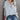 Women's beige hoodie featuring a casual buttoned pullover design with ribbed cuffs, shown in a gray variant, size XXL. The hoodie is displayed as part of an outerwear fashion ensemble, highlighting its long sleeves and comfortable fit.