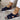 Women's beige mesh sandals featuring a stylish ankle chain design. The image focuses on the sandals, highlighting their comfortable flat sole and open-toe style. The sandals are shown on a model's foot, emphasizing their fit and fashionable appeal.
