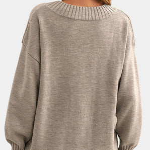 Women's beige oversized V-neck sweater with long sleeves, showcased as cozy fall knitwear.