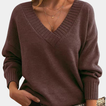 Women's oversized v-neck sweater in beige, featuring long sleeves and a cozy, knitted texture, perfect for fall wear.