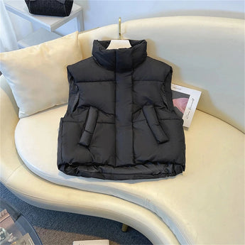 Women's beige sleeveless puffer vest, lightweight and insulated, designed for winter wear.
