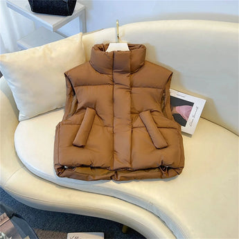 Women's beige sleeveless puffer vest in a lightweight insulated design, size 2XL, displayed on a wooden background.