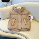 Beige sleeveless puffer vest for women, shown in a lightweight, insulated design suitable for winter; displayed on a chair, with a focus on comfort and fashion.