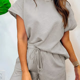 Women's gray summer romper set featuring textured fabric and a drawstring waist, worn by a model with shoulder-length hair and a smiling expression.