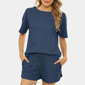 Women's blue athletic shorts set in XL size displayed on a person, featuring quick-dry and breathable fabric, with a white jersey top highlighting the arm and waist areas.