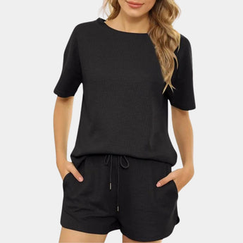 Women's black athletic shorts set in size XL, featuring a quick-dry, breathable material. The set includes a black jersey-style top with short sleeves and a crew neck, highlighting its suitability for activewear. The image shows the outfit on a model, emphasizing the fit and style.