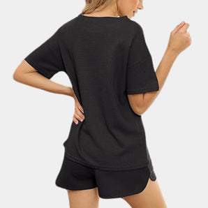 Women's black athletic shorts set modeled on a person, showcasing quick-dry, breathable activewear. The image highlights elements such as the fit around the arms, shoulders, and legs, with focus on the overall sporty and comfortable design suitable for various physical activities.