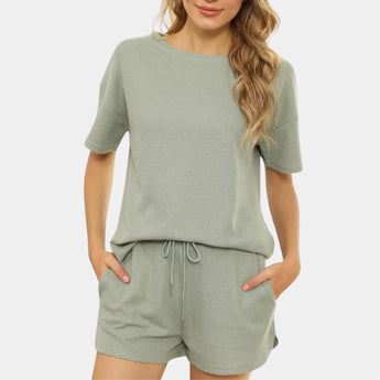 
A gray and black athletic shorts set for women, designed for activewear with quick-dry and breathable materials. The set features short sleeves and a comfortable fit, suitable for workouts, shown in size XL.