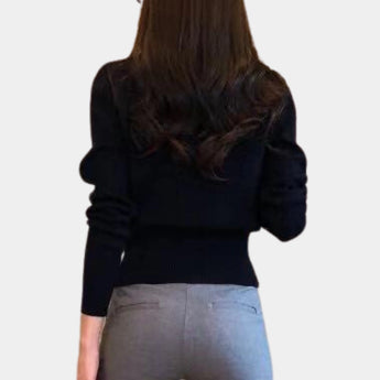 Woman wearing a black V-neck cardigan with gold buttons, styled for chic office wear.