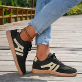 Women's black casual sneakers with a stylish contrast sole, showcased with a person wearing denim jeans.