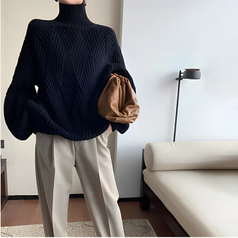Women's black chunky knit oversized turtleneck sweater featuring long sleeves and a cozy fit, perfect for winter fashion.