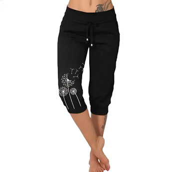 Woman wearing black capri pants with dandelion print, suitable for casual summer wear.