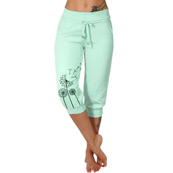 Woman wearing light green capri pants with black dandelion print, suitable for casual summer wear, shown in a 5XL size.