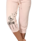 Women's black capri pants with white dandelion print, modeled by a person wearing a pink top, suitable for casual summer wear, lightweight and comfortable fit in size 5XL.
