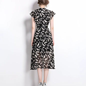 Women's black floral midi dress with sheer cap sleeves, featuring an elegant design suitable for summer, highlighting the neckline and waist.