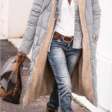 Women's oversized puffer coat in gray, featuring a hood and urban street style design.