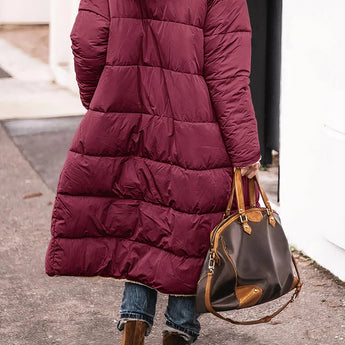 Women's oversized puffer coat in black with a hood, featuring a street style design. The coat is shown in a Bordeaux color variant and is size 3XL. The image highlights details like the coat's sleeves, shoulder fit, and tailored waist, emphasizing its fashionable and urban look.