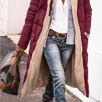 Women's black hooded oversized puffer coat with an urban street style design, featuring a cozy, padded exterior and a relaxed fit, shown in combination with casual jeans and a white dress shirt.