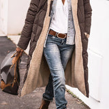 Women's brown oversized puffer coat in urban street style, featuring a hood and worn by a model standing with a casual look.