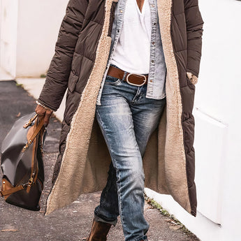 Women's brown oversized puffer coat in urban street style, featuring a hood and worn by a model standing with a casual look.