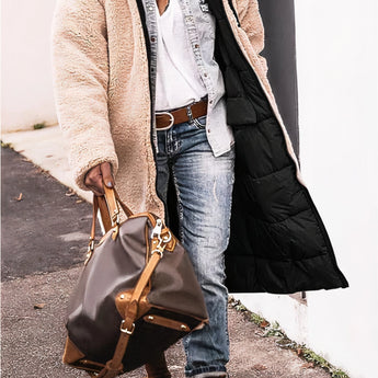 Women's black hooded oversized puffer coat in urban street style, paired with blue jeans and a white shirt.