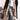 Black oversized puffer coat with a hood, styled for urban street fashion, worn by a woman. The coat is paired with jeans and is in a 3XL size.