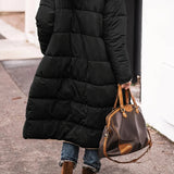 Women's black hooded oversized puffer coat in an urban street style, featuring long sleeves and a spacious fit.