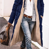 Women's black oversized puffer coat with a hood, styled in an urban street fashion. The coat features a quilted design with an emphasis on warmth and comfort, showcasing long sleeves and a loose fit. The image highlights the upper body, focusing on the coat's structure and texture.