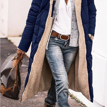 Women's black oversized puffer coat with a hood, styled in an urban street fashion. The coat features a quilted design with an emphasis on warmth and comfort, showcasing long sleeves and a loose fit. The image highlights the upper body, focusing on the coat's structure and texture.