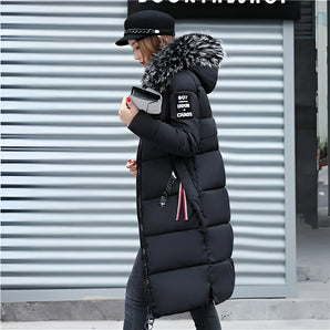 Women's black insulated puffer coat with faux fur hood, 4XL, featuring long sleeves and waist-length design, modeled outdoors.