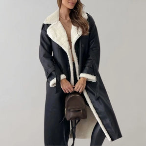 Women's black leather shearling coat with a luxurious design, featuring a knee-length overcoat style, a structured collar, and long sleeves. The coat provides warmth and elegance for winter, shown in black color and XL size.