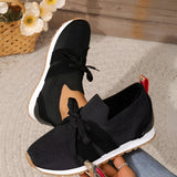 Women's black mesh breathable running sneakers, lightweight slip-on design, displayed against a neutral background, showcasing the synthetic rubber sole and athletic build.