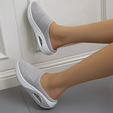 Women's gray mesh slip-on sneaker shown on a person's foot, highlighting its lightweight and breathable design.