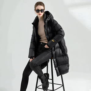 A woman wearing a black oversized hooded puffer coat, styled with sunglasses, showcasing a luxury winter fashion look.