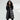 Oversized women's black hooded puffer coat, styled as a luxurious winter jacket, worn by a model who is also wearing sunglasses. The coat features long sleeves and a spacious fit, suitable for cold weather.