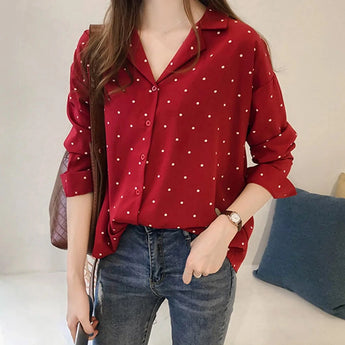 
A women's black polka dot blouse with an elegant loose fit, suitable for office wear. The blouse features a classic collar, long sleeves, and a relaxed silhouette, perfect for pairing with jeans or dress pants.
