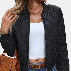 Women's black quilted bomber jacket, featuring a lightweight design ideal for fall, with a zip-up front and ribbed collar and cuffs, shown paired with jeans.