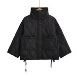 Woman wearing a black quilted puffer jacket, featuring a water-resistant and insulated design with a hood, suitable for cold weather.