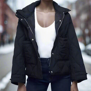 Women's black quilted puffer jacket with a hood, featuring insulated and water-resistant material, showcasing long sleeves and a high collar for added warmth and style.