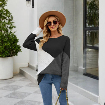 Women's black ribbed color block sweater featuring white cuffs, styled in a casual knitwear design, shown worn by a model accessorized with a fedora hat and sunglasses.