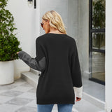 Women's black ribbed sweater featuring color block design with white cuffs, showcasing long sleeves and a comfortable fit suitable for casual wear.