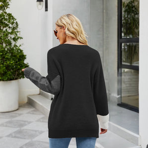Women's black ribbed sweater featuring color block design with white cuffs, showcasing long sleeves and a comfortable fit suitable for casual wear.
