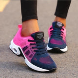 Women's black running sneakers with breathable mesh and cushioned sole featuring pink and blue accents, size 42, shown on a person wearing sportswear.