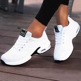 Women's white running sneakers with breathable mesh material and cushioned sole, designed for athletic activities and comfort.