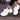 Women's white running sneakers with breathable mesh material and cushioned sole, designed for athletic activities and comfort.