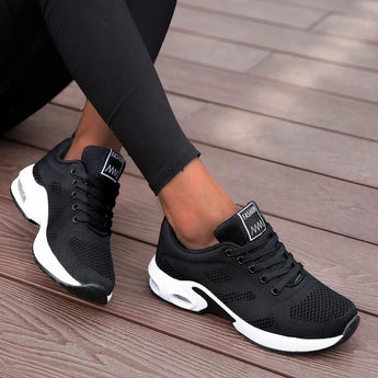 Women's black running sneakers featuring breathable mesh and a cushioned sole, shown in the color Nero and size 42, placed on a grey flooring surface.