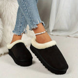 Women's black fuzzy lined shearling platform loafers being worn by a person dressed in jeans and a jacket, showcasing the footwear's stylish and cozy design.