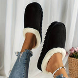 Women's black shearling fuzzy lined platform loafers on a model's feet, showcasing the footwear's stylish design and cozy lining against a neutral background.